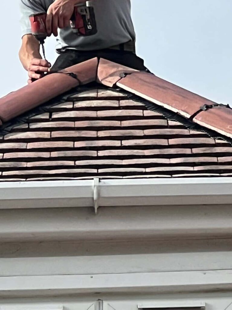 This is a photo of one of the operatives of Rugeley Roofing Repairs installing new ridge tiles